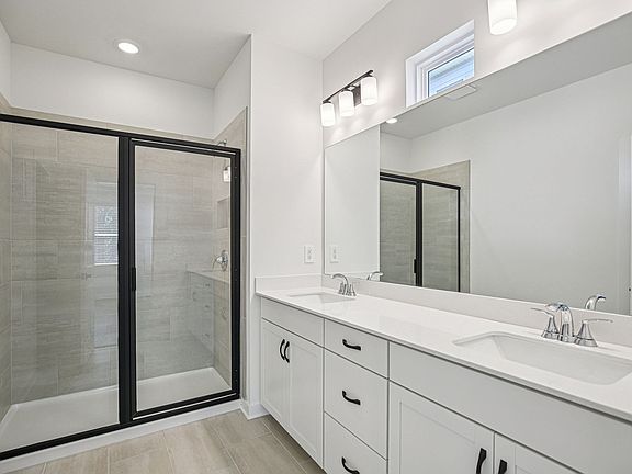 The primary bathroom offers dual vanity sinks and a walk-in shower.