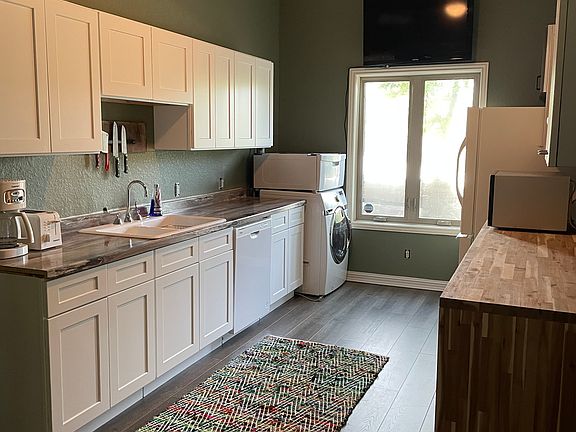 Kitchen with Whirlpool dishwasher, Kenmore Refrigerator, Toshiba 42 inch TV, Washer and stackable dryer.