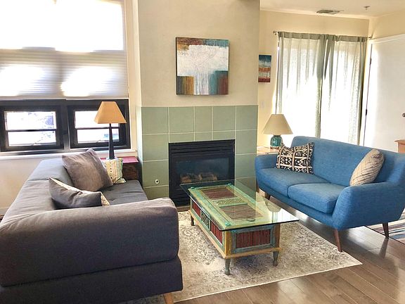 Living room with 2 couches. Couch on left converts to twin bed for guest. Gas fireplace.