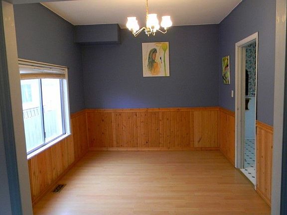 The dining room has laminate floors and the wainscoting on the walls adds nicely to the old-world ch