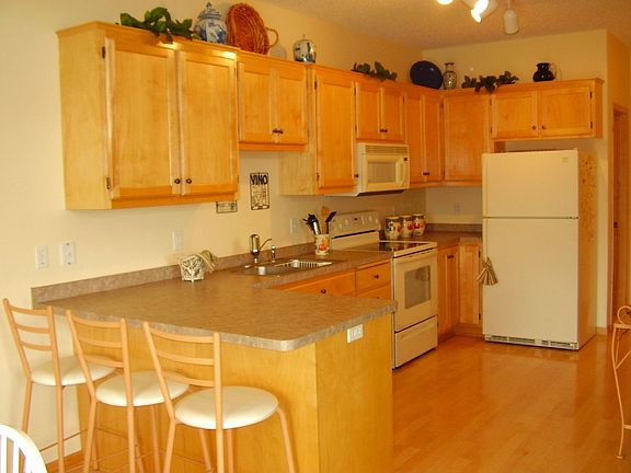 Sunlit kitchen with upgraded maple cabinets and flooring with breakfast bar!