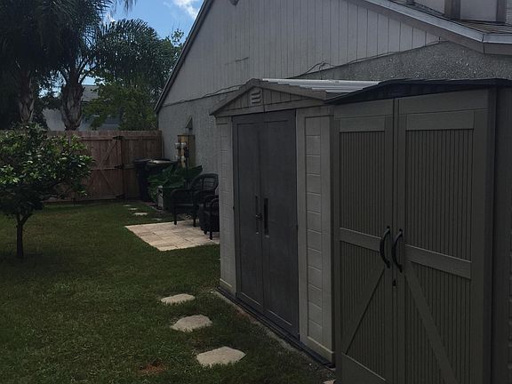 Side yard to include 2 storage sheds (lawn equipment located in shed on left side in this photo