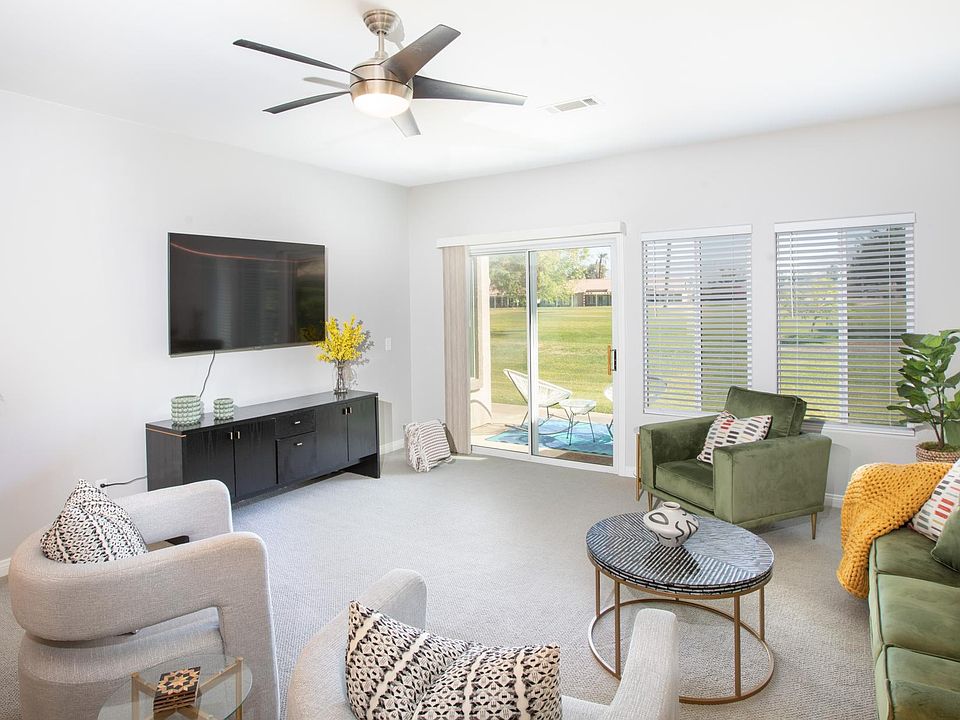 Living room with smart TV looking out to back patio and golf couorse.