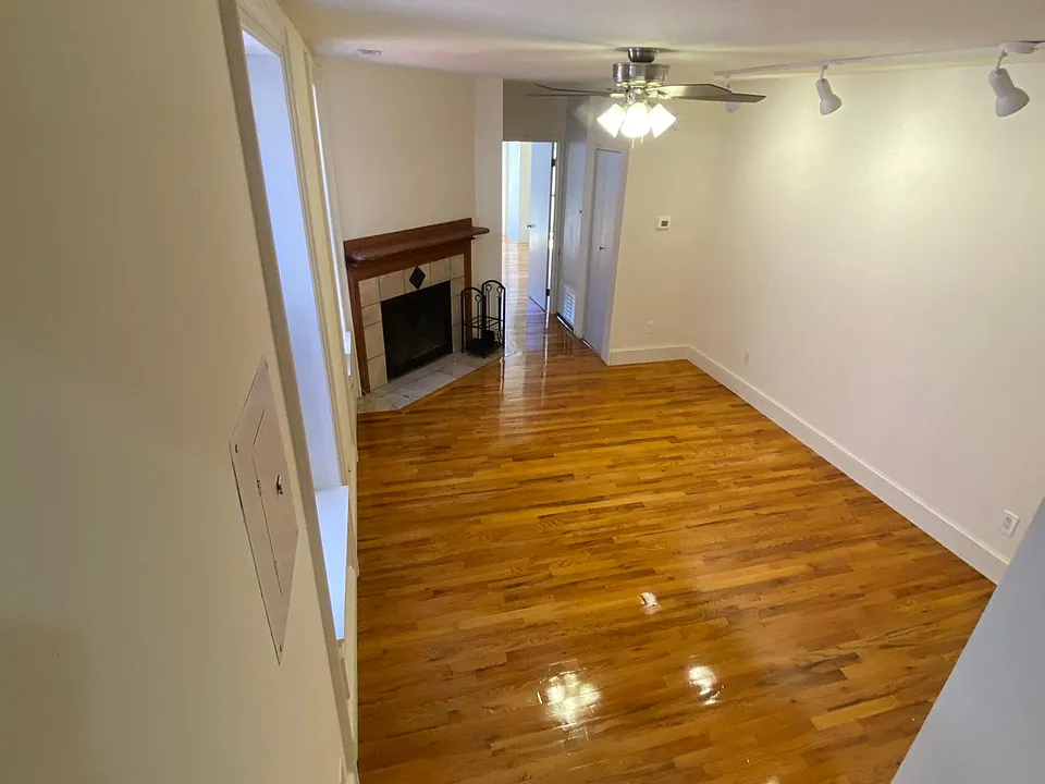 looking from the kitchen into the living room, with one bedroom behind the door to the far right.