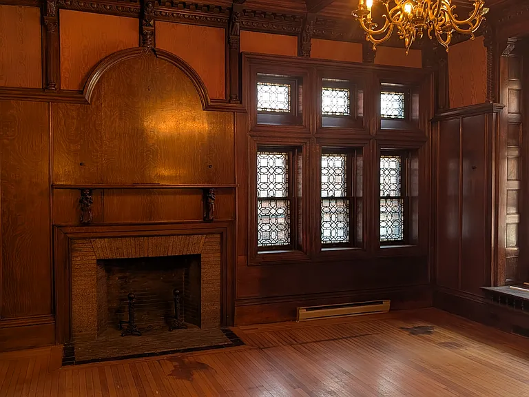 Living room with silk and wood paneled walls and hand carved detail