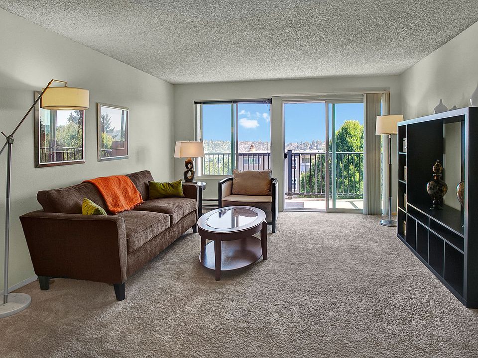 A spacious living room with two sliding glass doors that lead out to the private balcony
