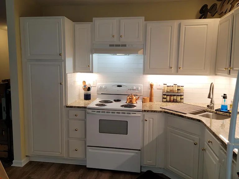 Kitchen with Granite countertops, subway tile backsplash, under cabinet lights, and new sink and faucet.