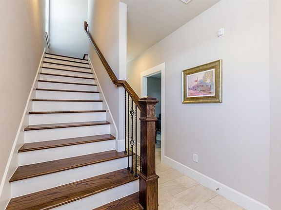 Stairway with wood risers, decorative wrought iron spindles and wood railings lead to the second and third floors of this beautiful townhome.