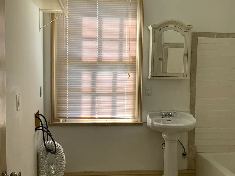 Entrance to bathroom; washing machine and dryer hookups on left.