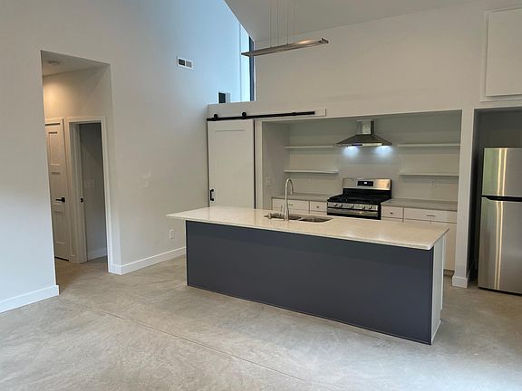 The kitchen includes an island for seating with new appliances - gas range, refrigerator (w/ ice machine), dishwasher, disposal, washer & dryer