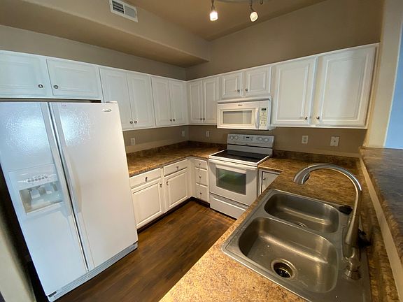 Kitchen with double sink, garbage disposal, microwave, glass top stove.
