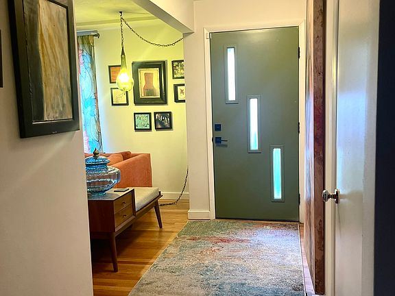 Interior shot of Front Entry Door, Entry area, Coat Closet on right, Living Room on left, Dining Room behind.
