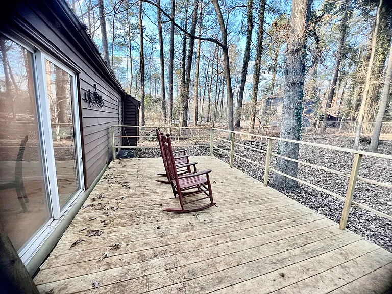 Back porch off of kitchen with fenced in wooded backyard.