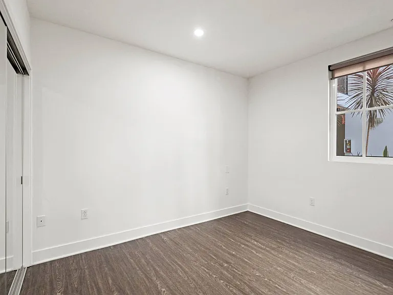 Bedroom with Mirrored Closet, Window, and Vinyl Flooring