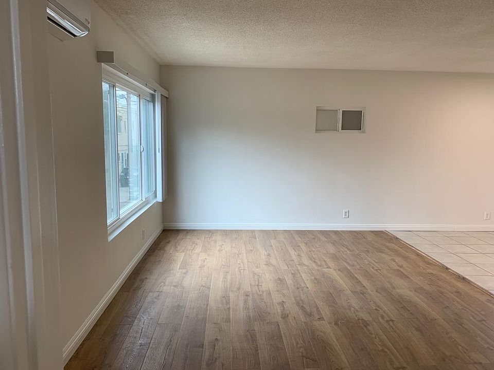 living room with huge window with blinds for sunlight. 2 in one AC/ Heater unit