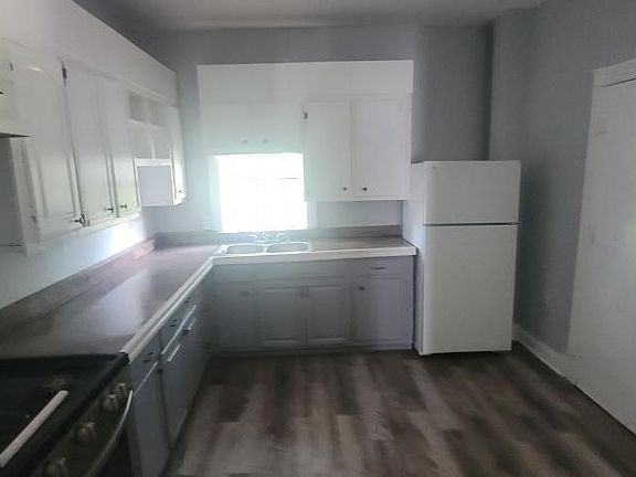 Clean, spacious kitchen w/ view of back door that leads to the back porch and rear yard area