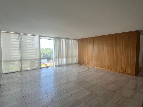 Large living room with travertine floors, beautiful wall of built-in closets, sleek appearance, floor to ceiling windows- fantastic light and Mountain Views