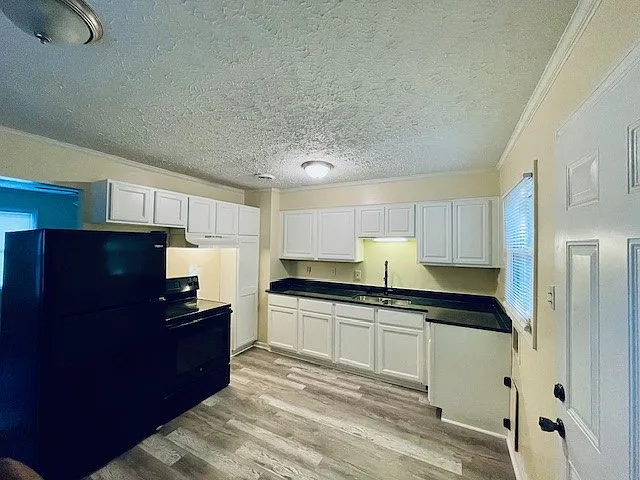 _ Freshly renovated cozy kitchen alert! Featuring sleek black appliances, stunning granite countertops, and warm laminate wood flooring_perfect for whipping up meals with style! __ #KitchenGoals #HomeRenovation #CozyLiving