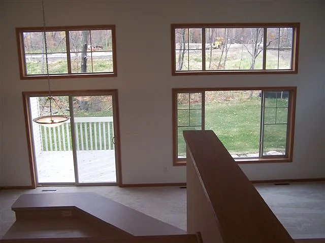 View from 2nd floor landing overlooking main floor kitchen, dining and living space. Walkout to deck from dining area.