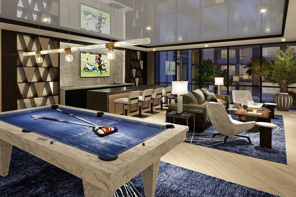 Expansive clubroom with wet bar, billiards, shuffleboard, and lounge areas.