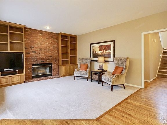 Family room with cozy fireplace and built-in cabinetry is fully open to kitchen & overlooks peaceful backyard.