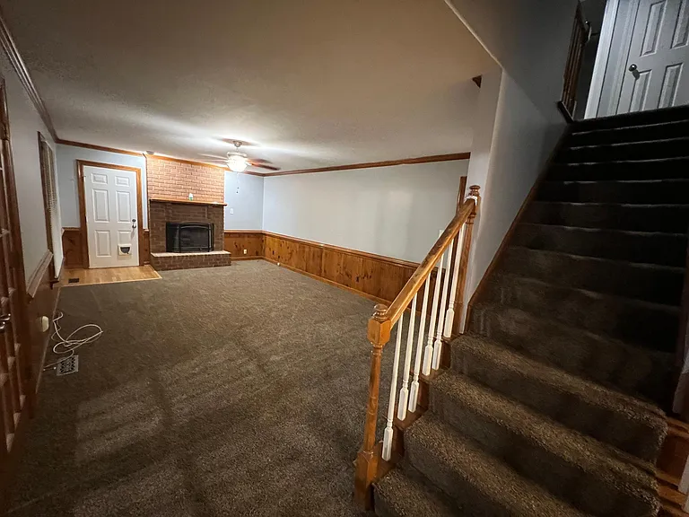 Photo of the stairwell to the upstairs looking into the family room
