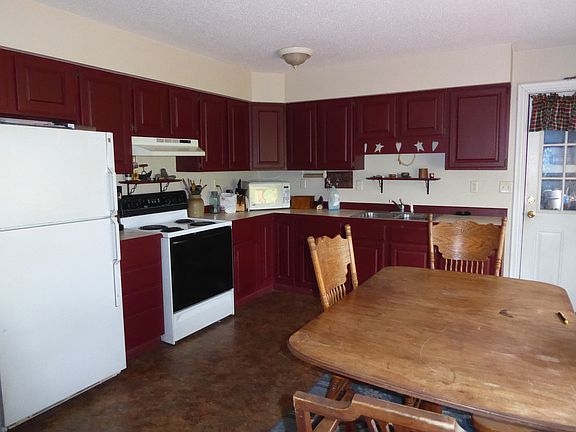A huge country kitchen overlooks the backyard and pond.