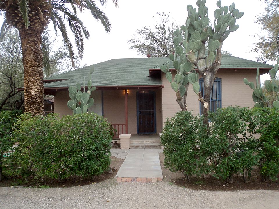 Bungalow style home with front porch and hedge.
