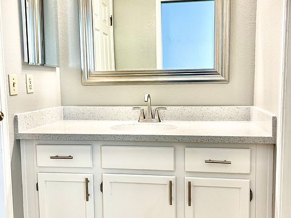 Primary Bathroom; new floor, counter, sink, mirror, faucet and light fixture.