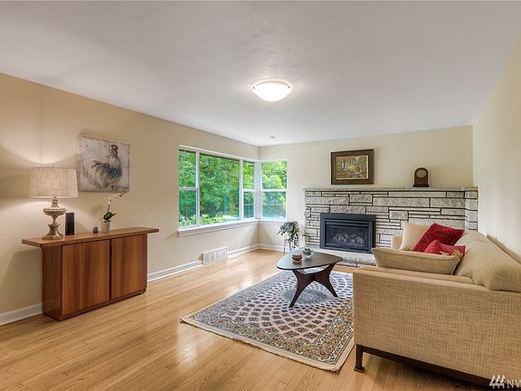 Step into the Living Room in this Mid Century home with Classic Sandstone Fireplace and Hardwood Floors.