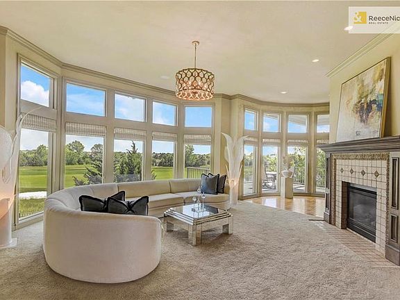 Enjoy the Wall of Windows with Spectacular View of Golf and Sunrise. Eastern exposure for the back of the home guarantee's cool Summer Evenings. Room has custom fireplace, new lighting fixture, woven woods window covering and tall ceilings.