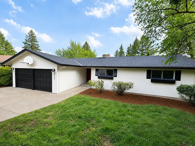 Front of home, large driveway for parking plus a garage, and plenty of yard space