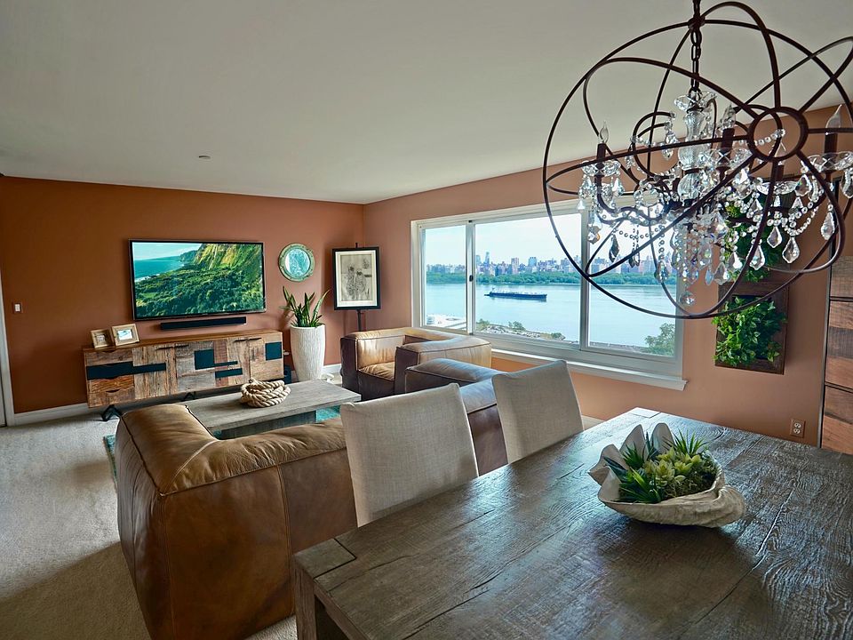 Sun drenched living and dining room with rare NYC and Hudson River views
