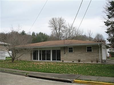 Front of house with large glass doors entering the sun room... very spacious with cut stone and a two car garage, but is walking distance to St Claire hospital, Morehead State University and downtown Morehead.