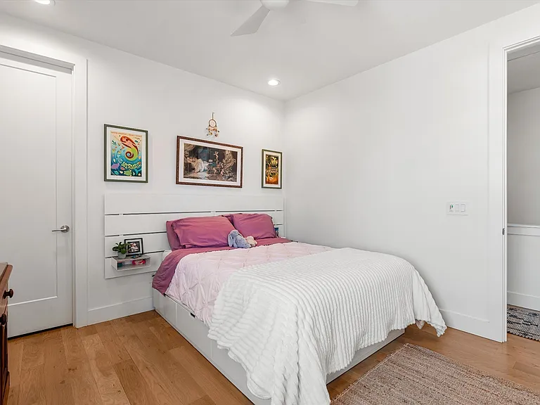 Secondary bedroom with hardwood floors and abundant natural light.