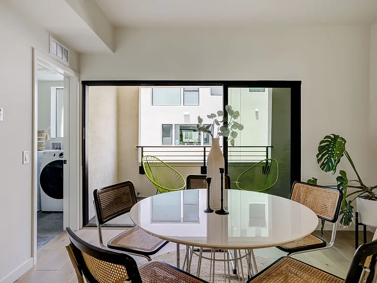 Dining area with sliding glass doors that open to a private balcony. Dedicated laundry room conveniently located just off the dining area.