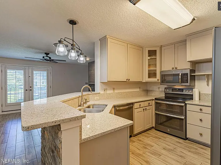 Quartz bar and countertops throughout, stainless steel appliances.