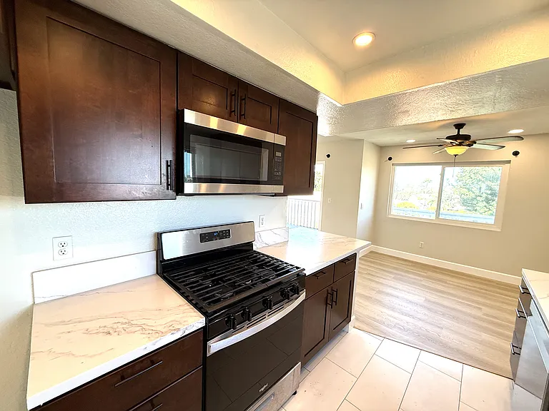 Kitchen with microwave over range and oven connected to dining room