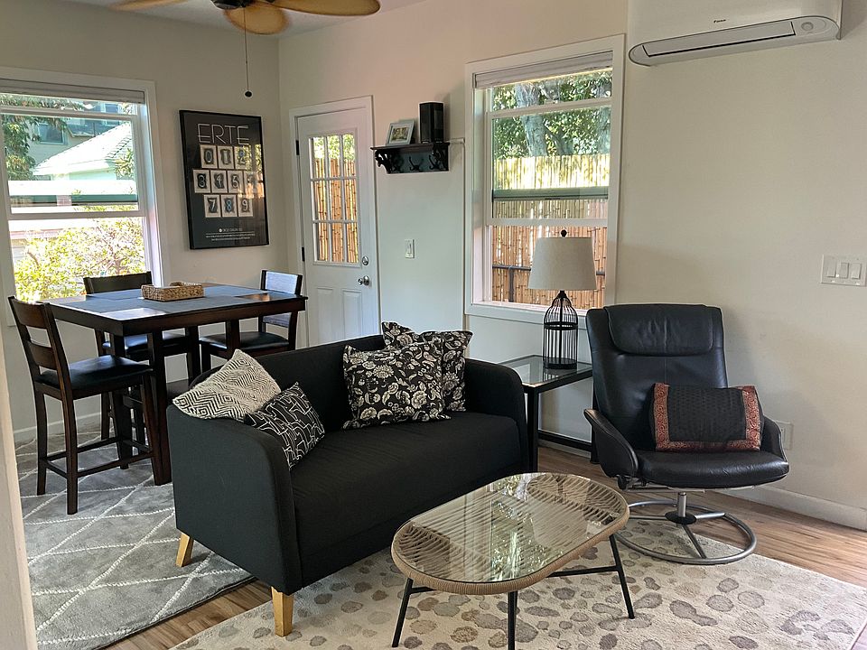 Living room and dining area with window onto private balcony and neighboring garden
