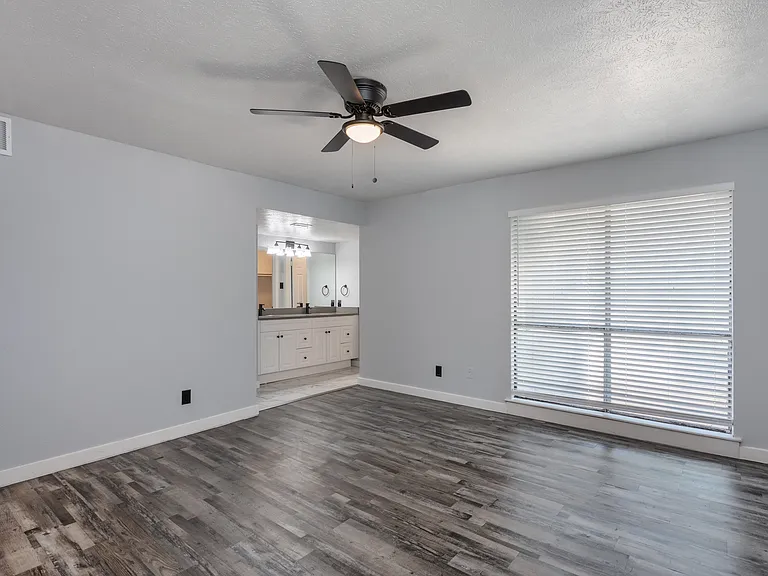 Spacious primary bedroom with large window