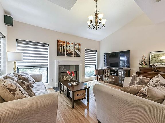 The Living Room (15x13) has a vaulted ceiling, elegant fireplace, and bamboo flooring. Notice the large windows overlooking courtyard.