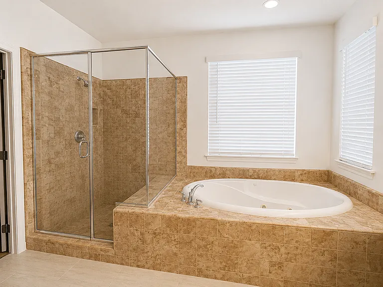 Primary suite bath with walk-in shower and jetted soaking tub
