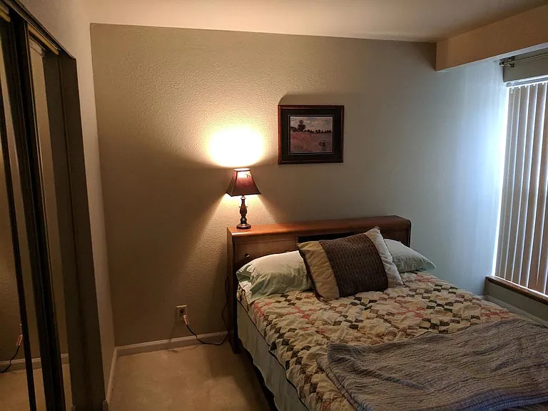Bedroom #1 bed and window facing parking lot.