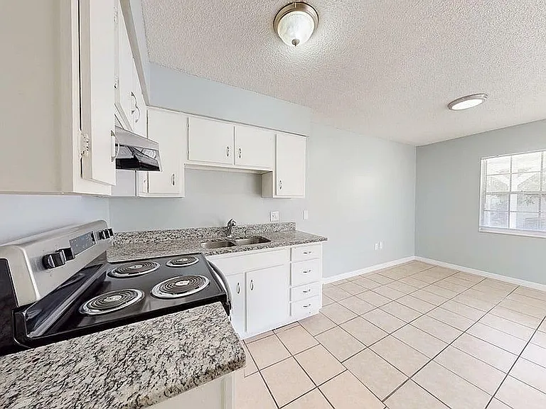Bright and airy kitchen with modern appliances, granite countertops, and spacious dining area, perfect for culinary enthusiasts.