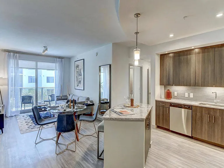 Kitchen features long upper cabinets, built-in lighting, and stainless steel appliances