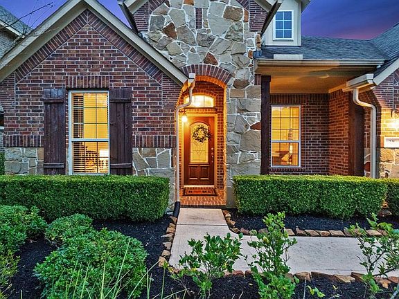 Brick and stone exterior with wooden shutters.