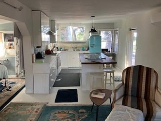 Fully remodeled kitchen with propane stove, butcherblock island, and sink with window looking out onto the view