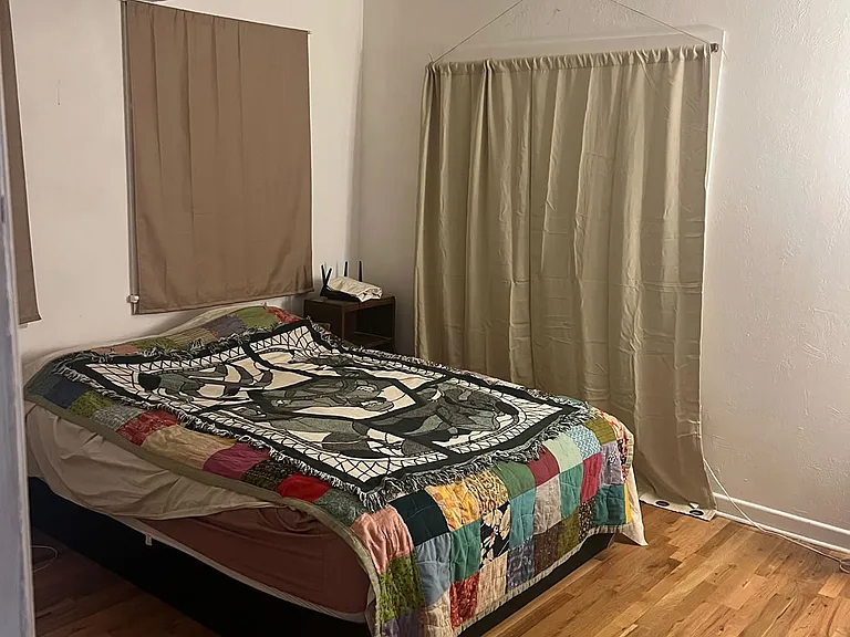 larger bedroom, curtain opens to sunroom and backyard