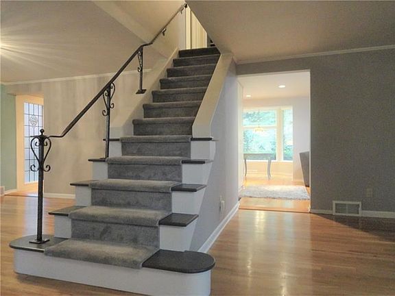 This photo shows the formal dining room to the left of the stair with side hallway to the kitchen.  The opening to the right of 