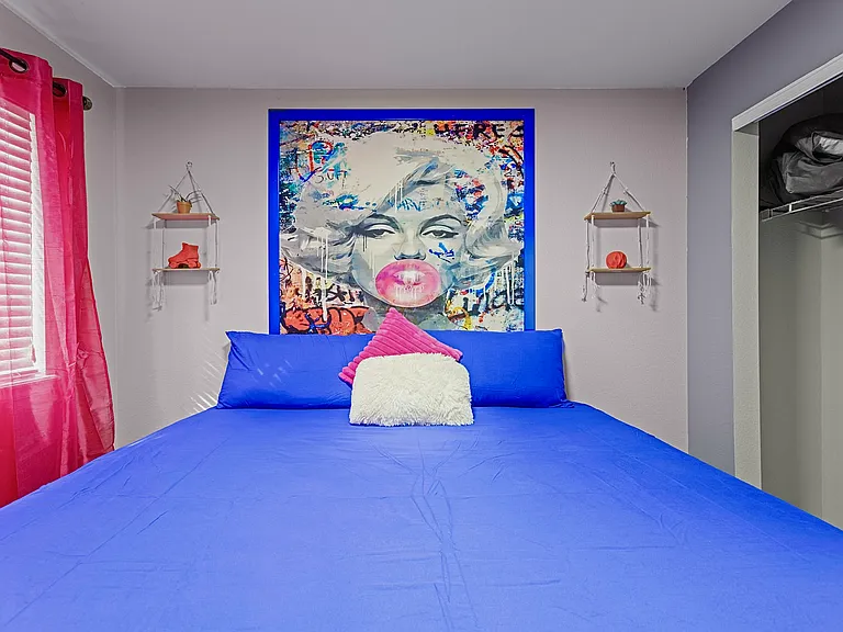 Bright and airy bedroom with a comfortable king-size bed and colorful decor. Perfect for a restful night's sleep.